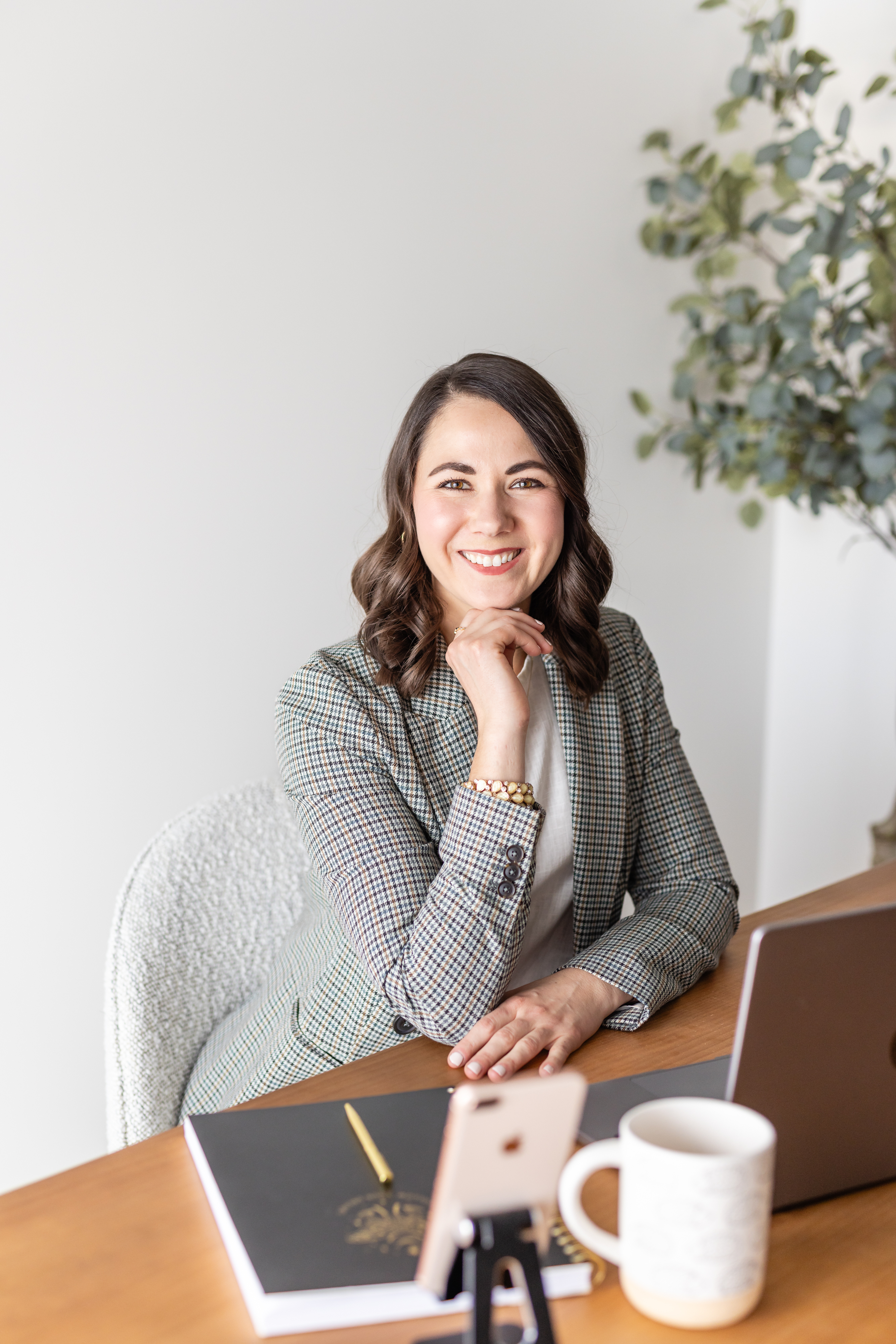 Brittany Miller — warm headshot at desk, chin resting on hand, smiling