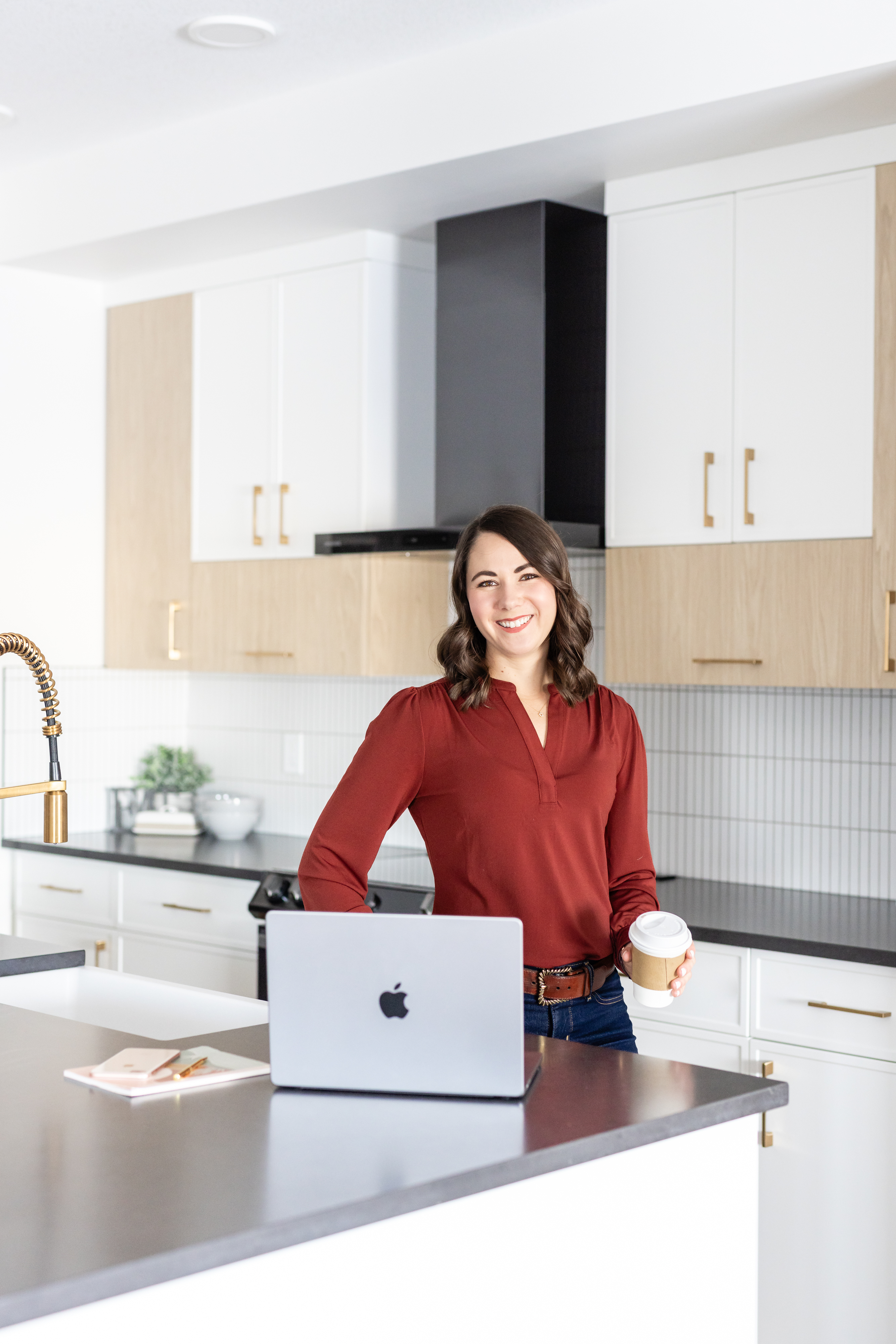 Brittany Miller at her desk with laptop, smiling — coaching session vibe