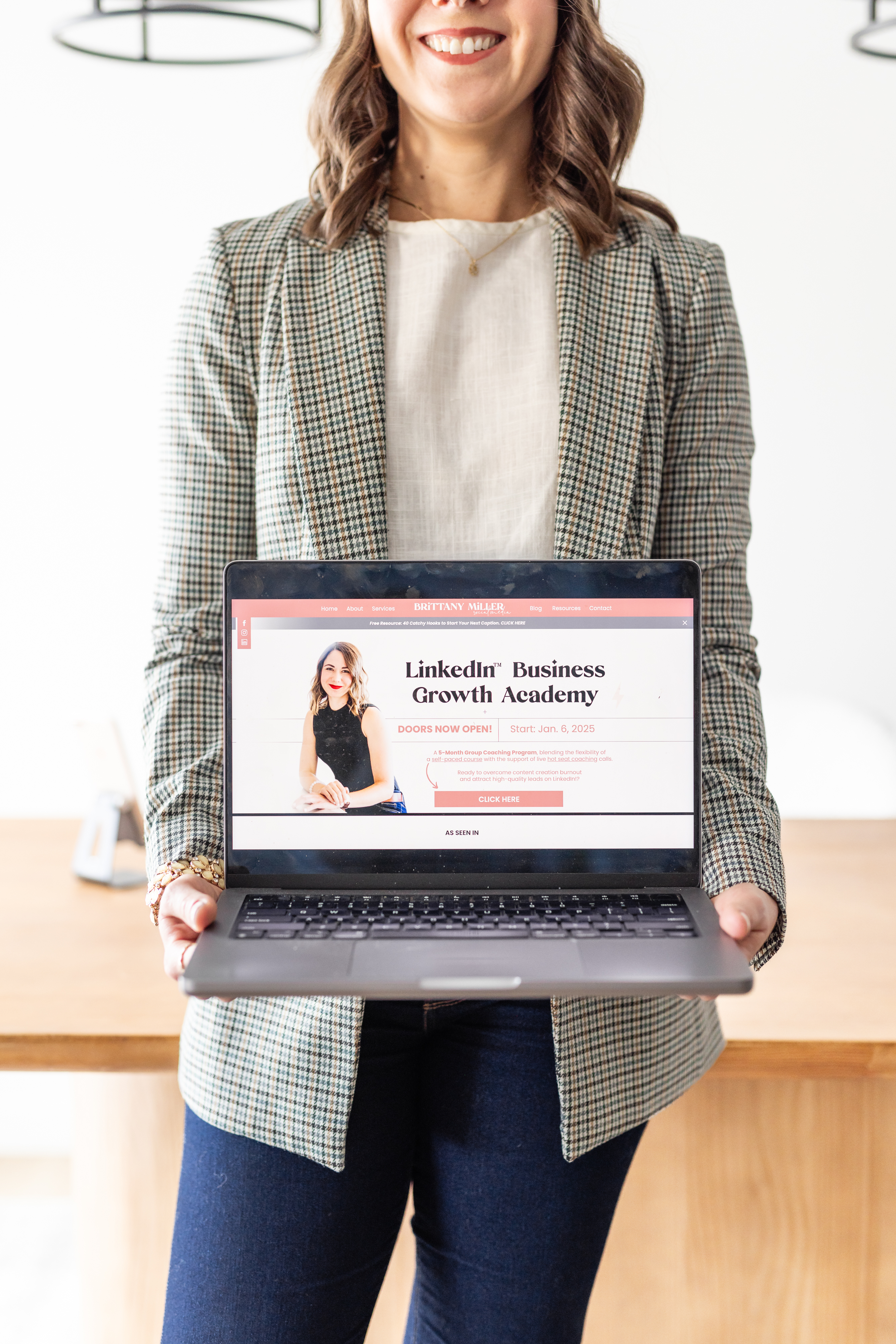 Brittany holding open MacBook showing the LinkedIn Business Growth Academy course portal